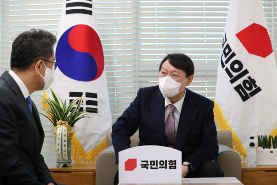 윤석열(오른쪽) 국민의힘 대선 후보가 15일 서울 영등포 국민의힘 당사에서 문재인 대통령의 축하 난 전달차 방문한 이철희 청와대 정무수석과 인사말을 나누고 있다. <국회사진기자단=연합뉴스>